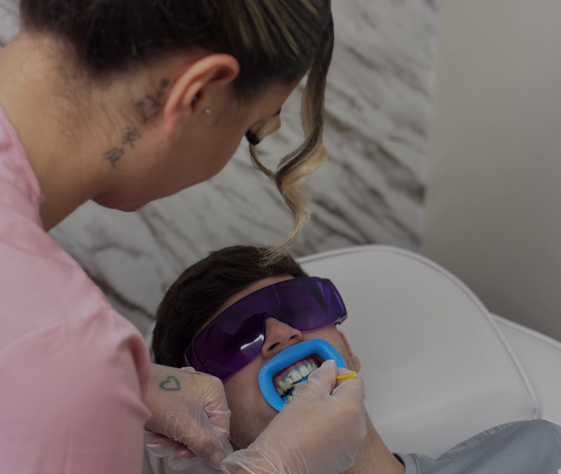 A practitioner carrying out a teeth brightening treatment at Glow Whitez in Birmingham