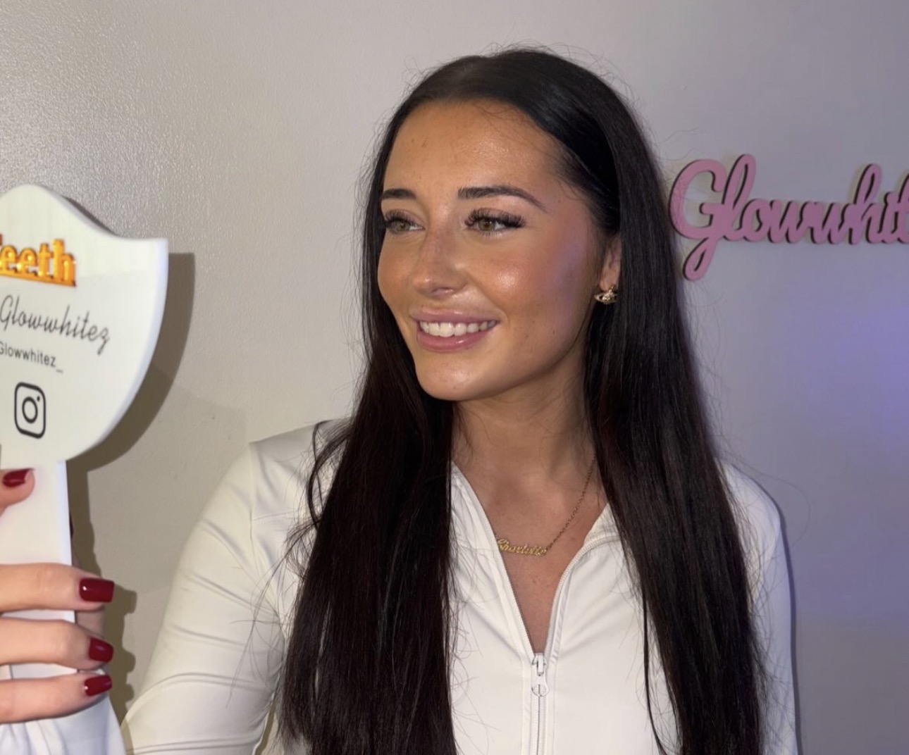 A client holding a Glow Whitez mirror in the studio